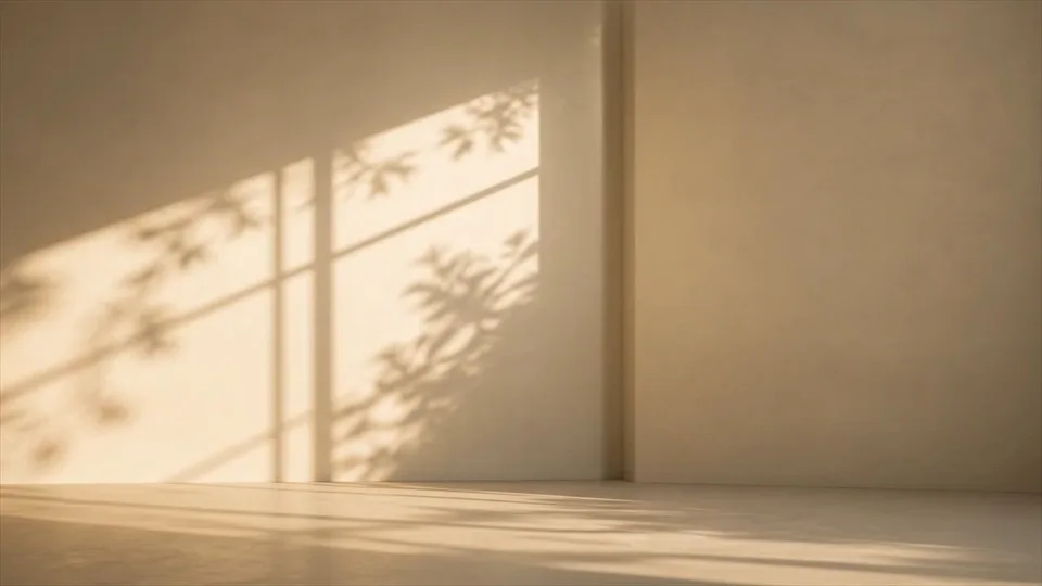 Suaves sombras de hojas se mueven sobre una pared cálida.