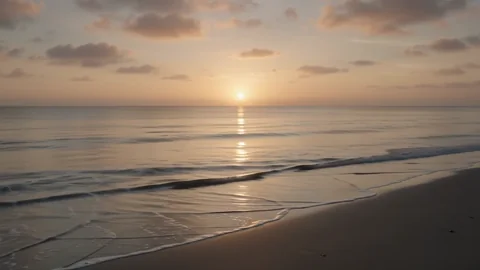 黄金の海岸 2. 夕日の暖かな光の中で、穏やかな海の波が寄せては返します。